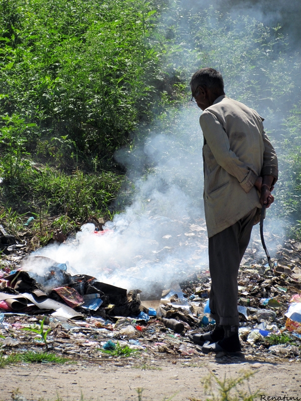 Fotografija starejšega gospoda, ki žge smeti