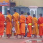 Photo of buddhist monks / Fotografija budističnih menihov v značilnih oblačilih, ki pobirajo jutranje darove vernikov.